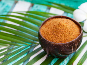 Coconut brown sugar in a wooden bowl. Tropical background buy coconut sugar